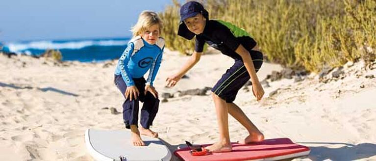 Boys at beach wearing UV protective clothing