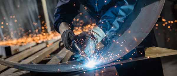 worker welding curved metal