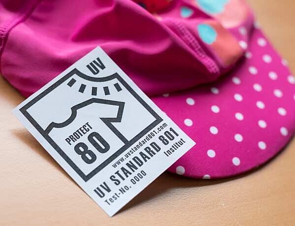 pink children's hat labeled with UV STANDARD 801 certification for 80 UPF
