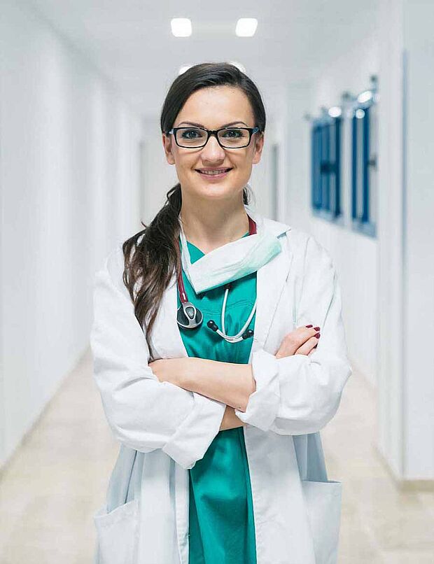 Doctor wearing scrubs, mask and lab coat