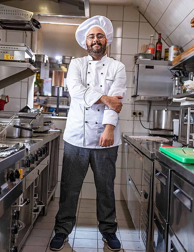 chef wearing hat and uniform in kitchen