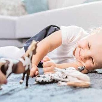 Child playing on carpeted floor with toys