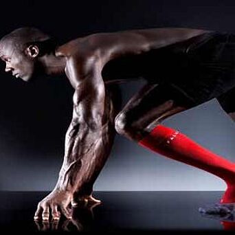 runner in athletic gear posed at starting blocks