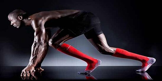 runner in athletic gear posed at starting blocks