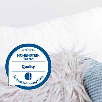 Hohenstein Quality Label and a child peeking out from behind a couch