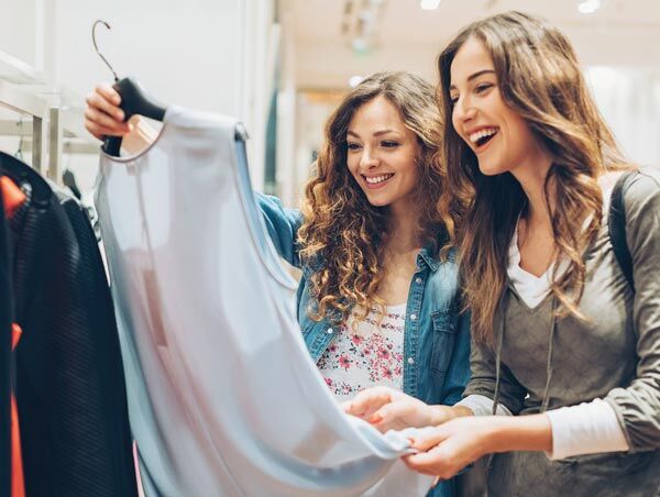 Two women looking at a shirt in a retail store