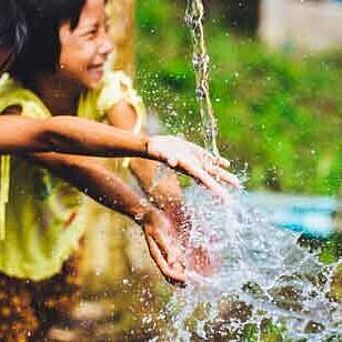 Two children splashing in clean water