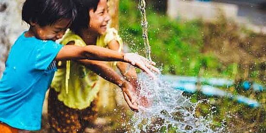 Two children splashing in clean water