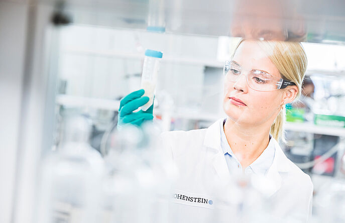 Chemist holding vial of wastewater in Hohenstein Lab