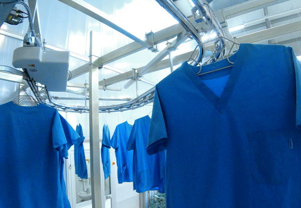 Blue scrubs on hangers in industrial laundry