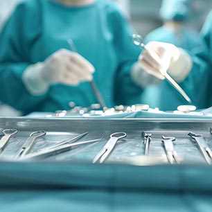 Surgeons in gowns and gloves hold sterilized medical instruments