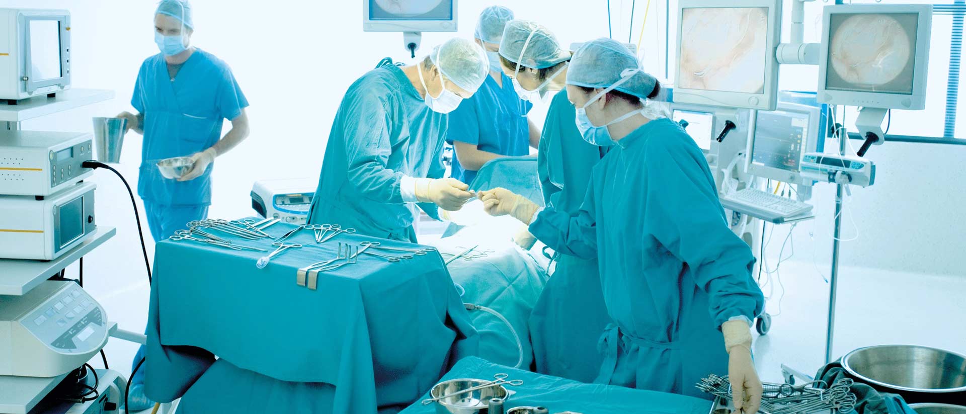 Sterile surgical drapes and gowns prepared on instrument table in operating room