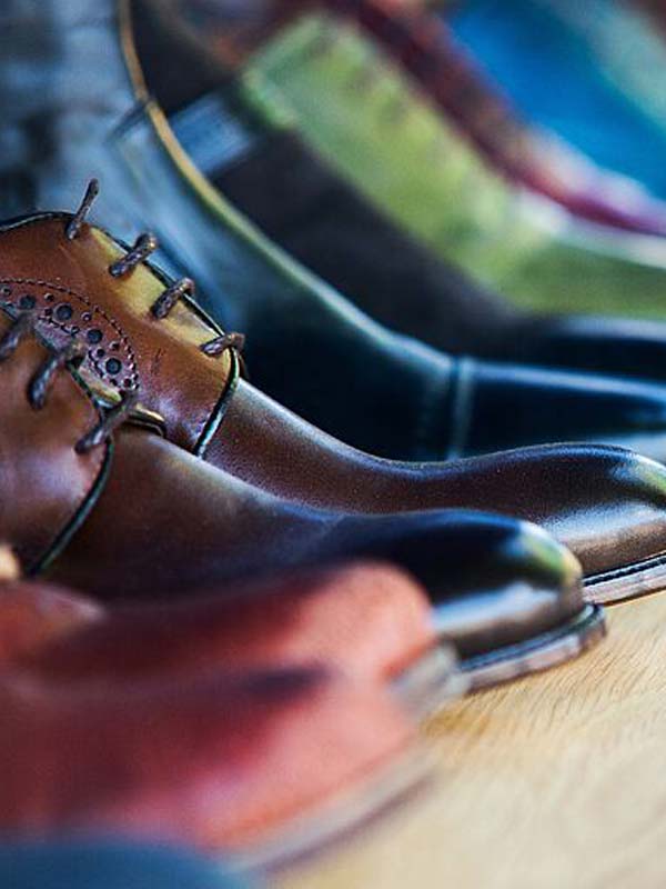 leather shoes and boots in several colors, lined up on a shelf