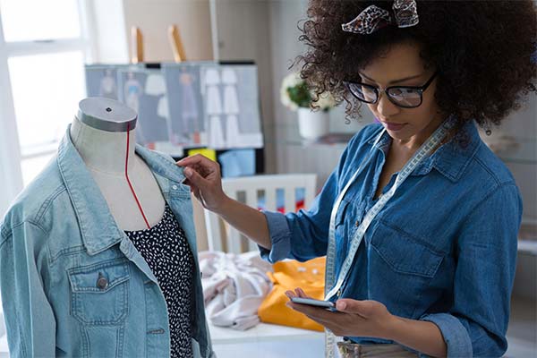 Designer working with with jean jacket and dress on bust