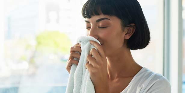 Woman smelling a fresh, white towel